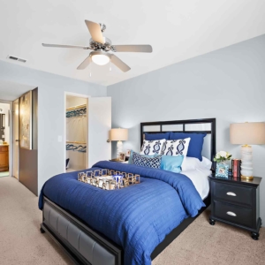 large bedroom with walk-in closet in model home at Pines at Marston